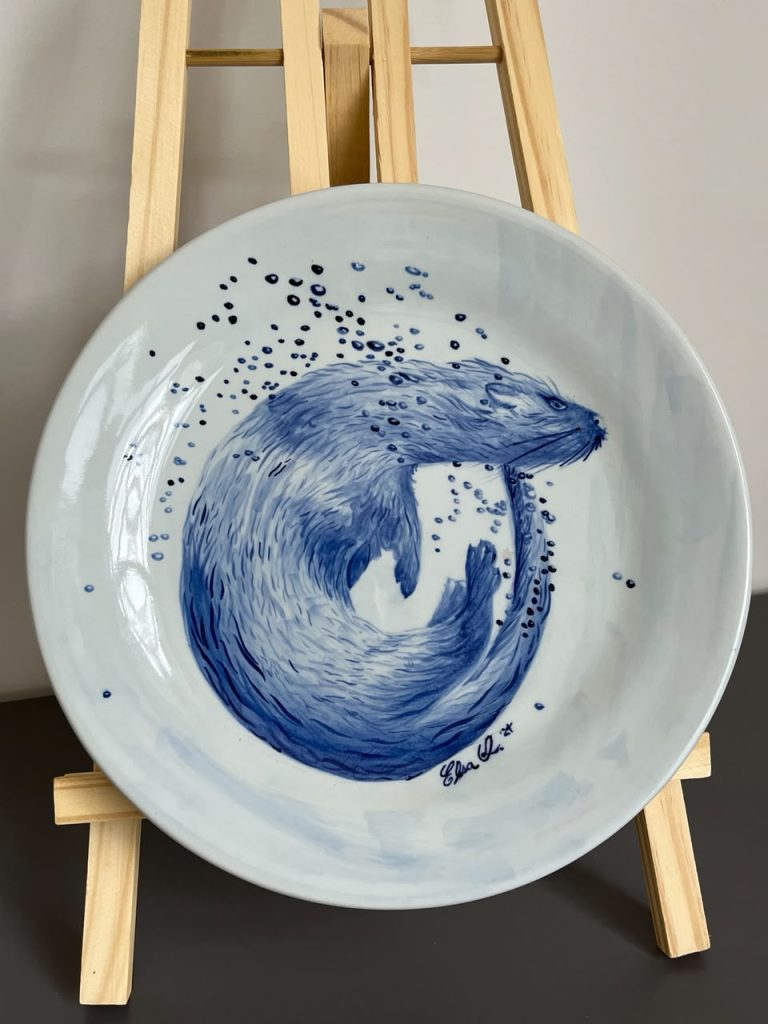 Nutria marina pintada a mano sobre un plato de cerámica en la técnica tradicional Azul de Delft