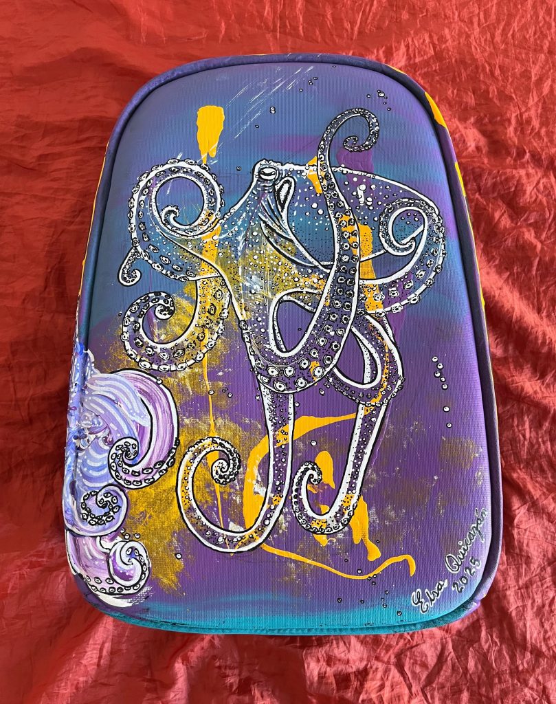 Front view of The Traveling Octopus painted on a hard-shell suitcase.