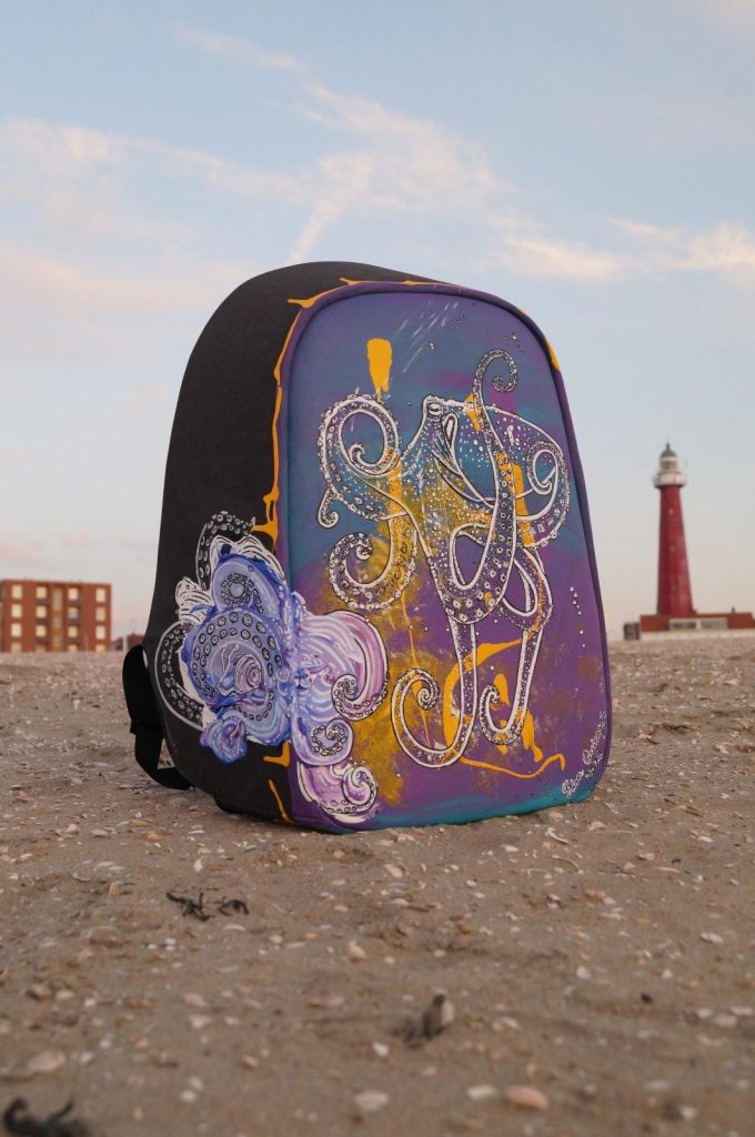 Acrylic-painted suitcase featuring a colorful octopus with the Scheveningen lighthouse in the background.